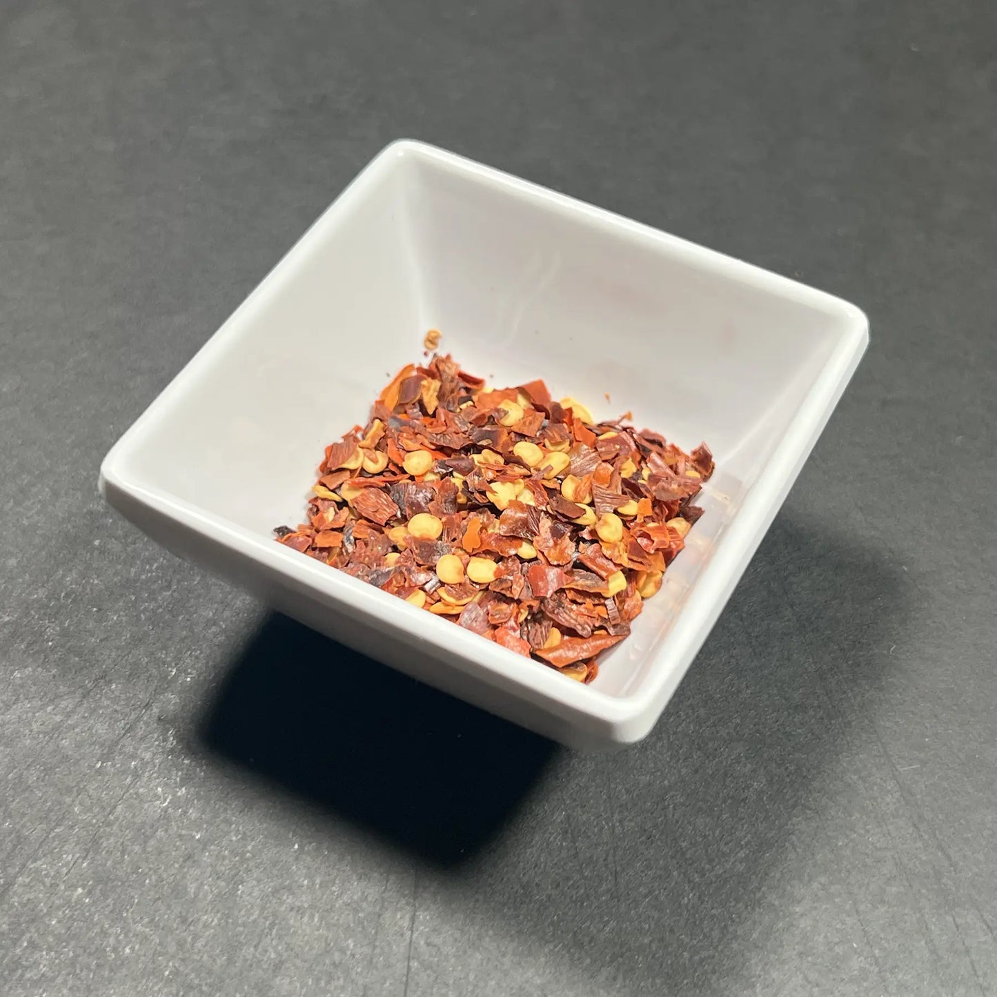 Premium crushed red chili flakes from Fire & Char in Richmond, VA. Perfect for adding a spicy kick to your pizza.